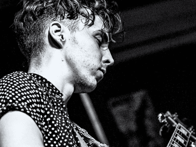 black and white image of tom playing guitar