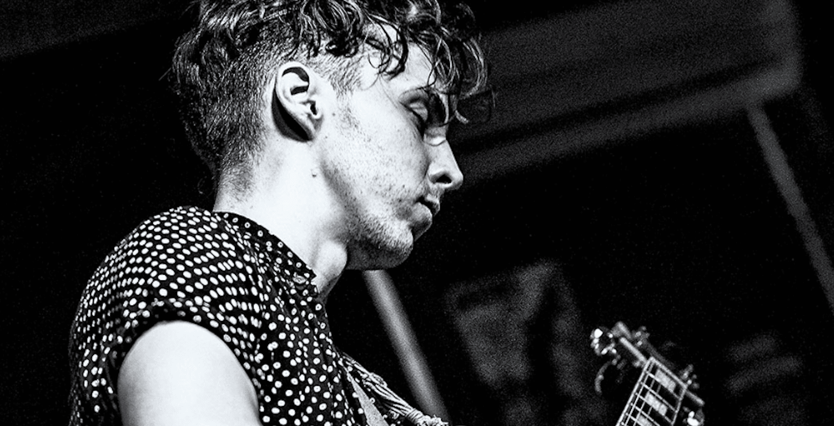 black and white image of tom playing guitar