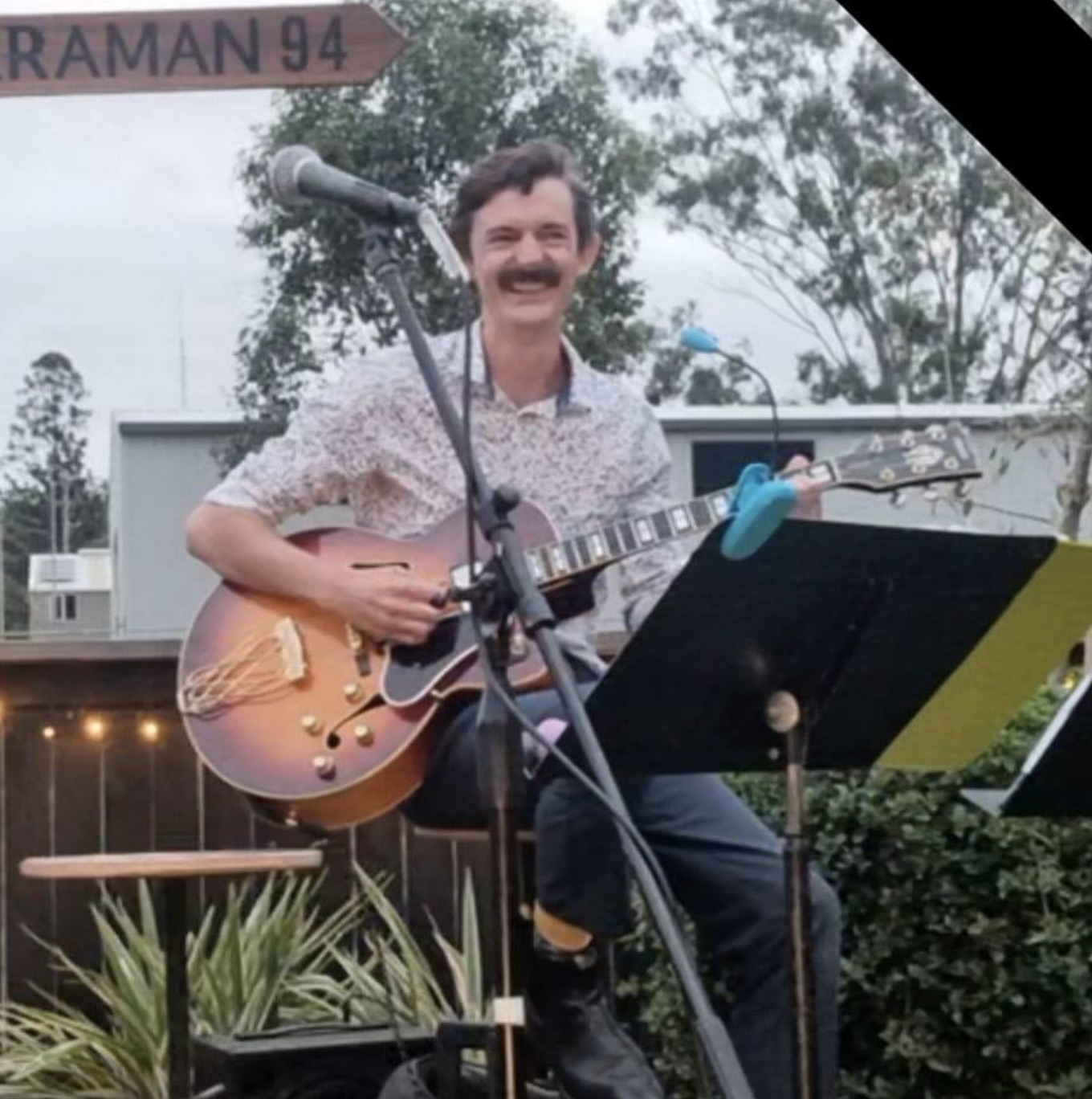 jesse performs guitar with a big smile on his face at local bar