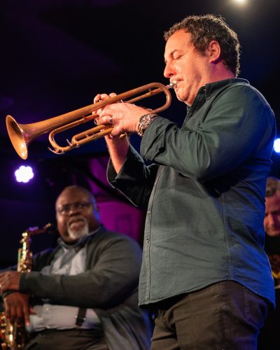dan quigley on stage playing trumpet