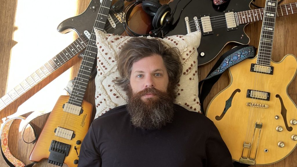 Davey Romain surrounded by guitars